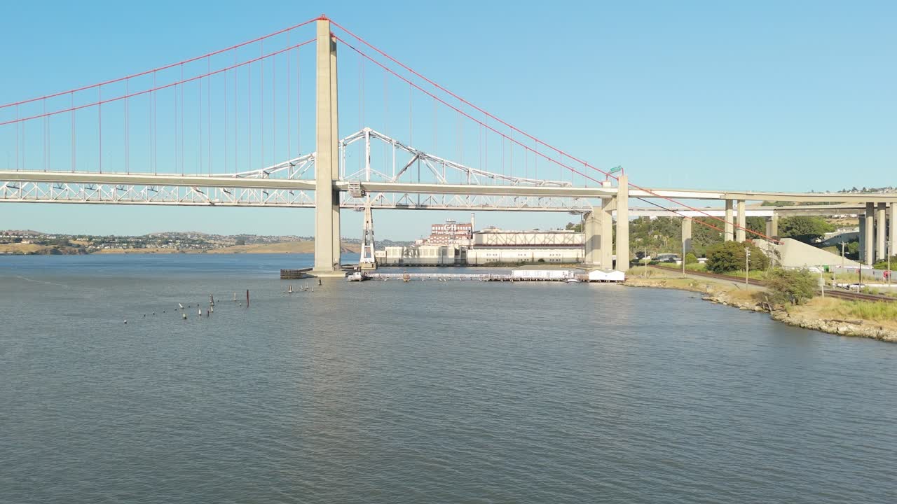 From Crockett’s edge, a drone offers an expansive glimpse of the bridge’s design, with parallel lanes and towering suspension captured in golden morning hues