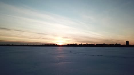 Puesta-De-Sol-Sobre-Un-Lago-Congelado,-Nieve,-Cámara-En-El-Futuro