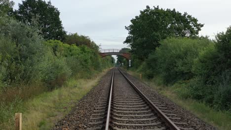 a drone flies in good weather at a very low altitude over railway tracks