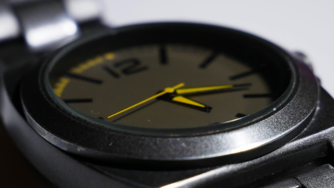 el movimiento de las manecillas amarillas de un reloj de pulsera