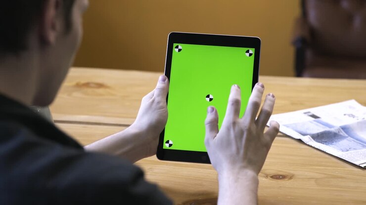 Persona che tiene un tablet con schermo verde