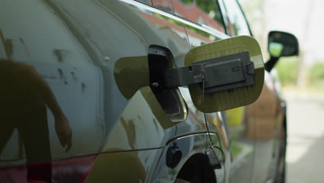 close up of driver stopping ev car at evse station to recharge it
