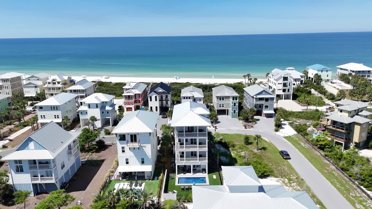 Drone fly over coastal community with houses near sandy beach towards turquoise ocean, Cape San Blas, Gulf County, Florida, USA