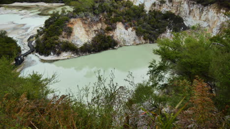 Toma-De-Arriba-Hacia-Abajo-Del-Lago-De-Color-Verde-Dentro-De-Un-Enorme-Cráter-Volcánico-En-Wai-o-tapu,-Nz