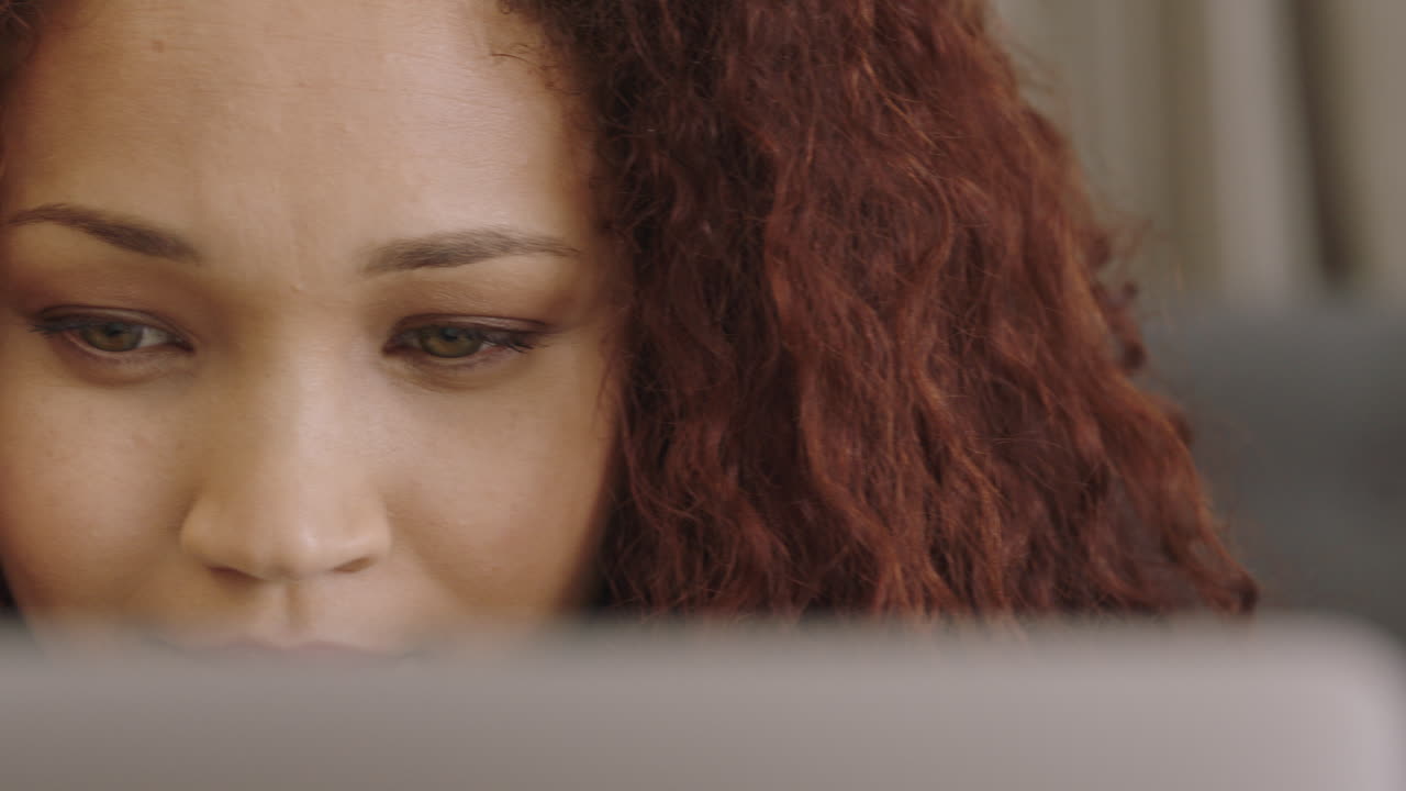 mujer joven de raza mixta que usa una tablet pc bloguera que trabaja en casa estudiante que navega por el sitio web en línea leyendo