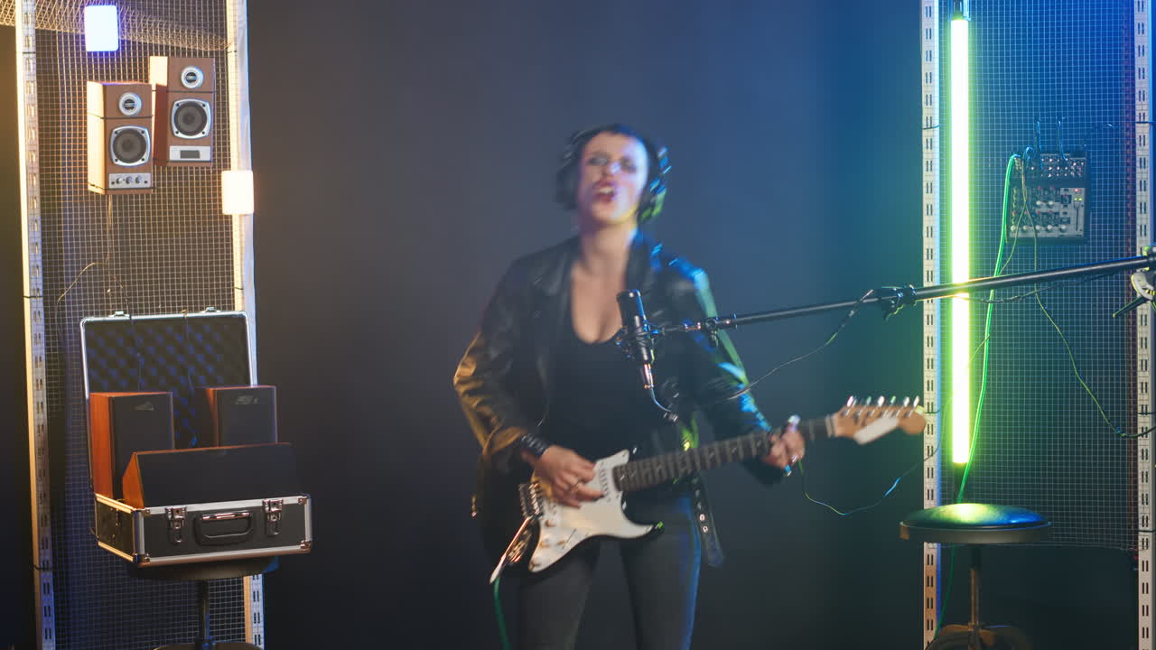 mujer tocando la guitarra eléctrica en el estudio de grabación