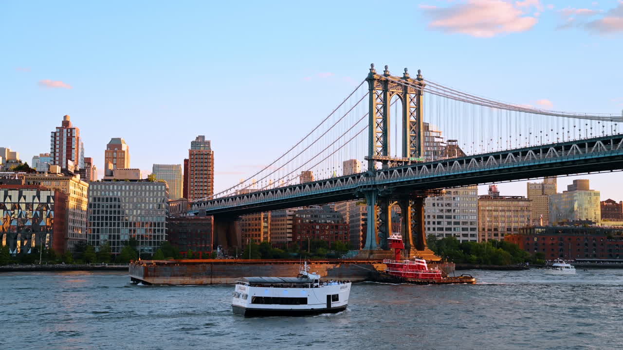 New York, USA, 2 agosto 2025: Barca turistica e rimorchiatore con chiatta sull'East River. Traffico marittimo con crociera passeggeri e nave industriale sotto il Ponte di Manhattan, New York.