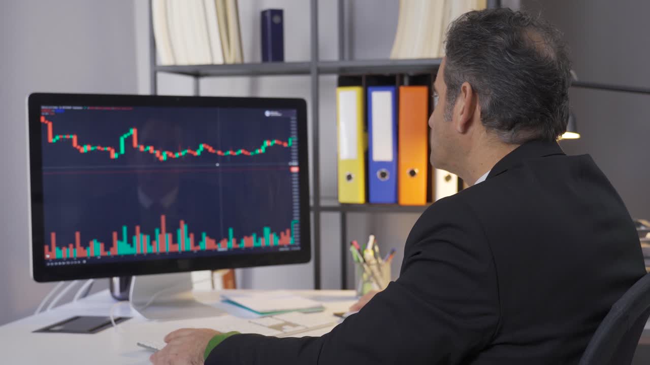 Mature businessman researching and analyzing stock market data.
