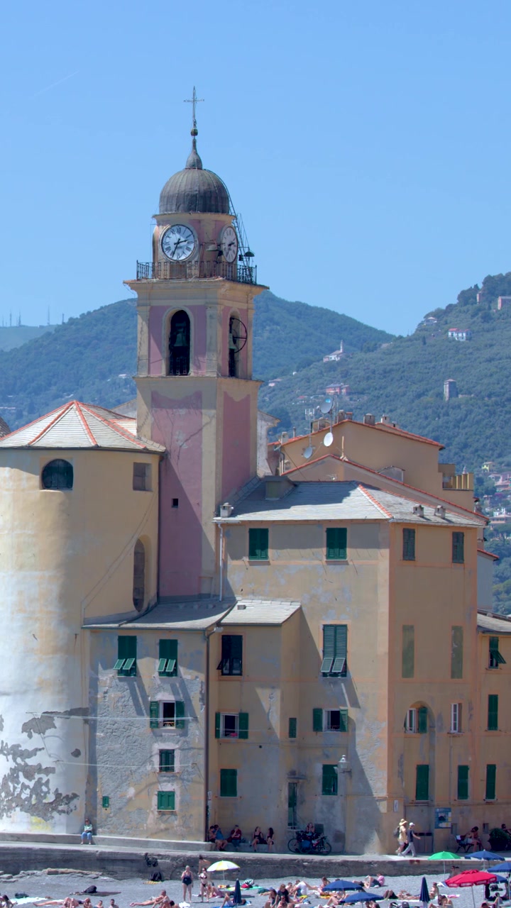 Lenta panoramica di colorati edifici mediterranei e una chiesa storica in riva al mare