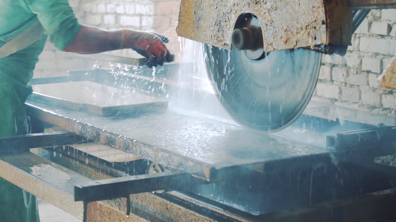 Cutting stone at the factory. Saw blade equipment sprays water on rock for cooling. Saw blade ror hard mineral cutting. Processing Equipment