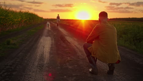 hombre observando a una mujer y un perro al atardecer