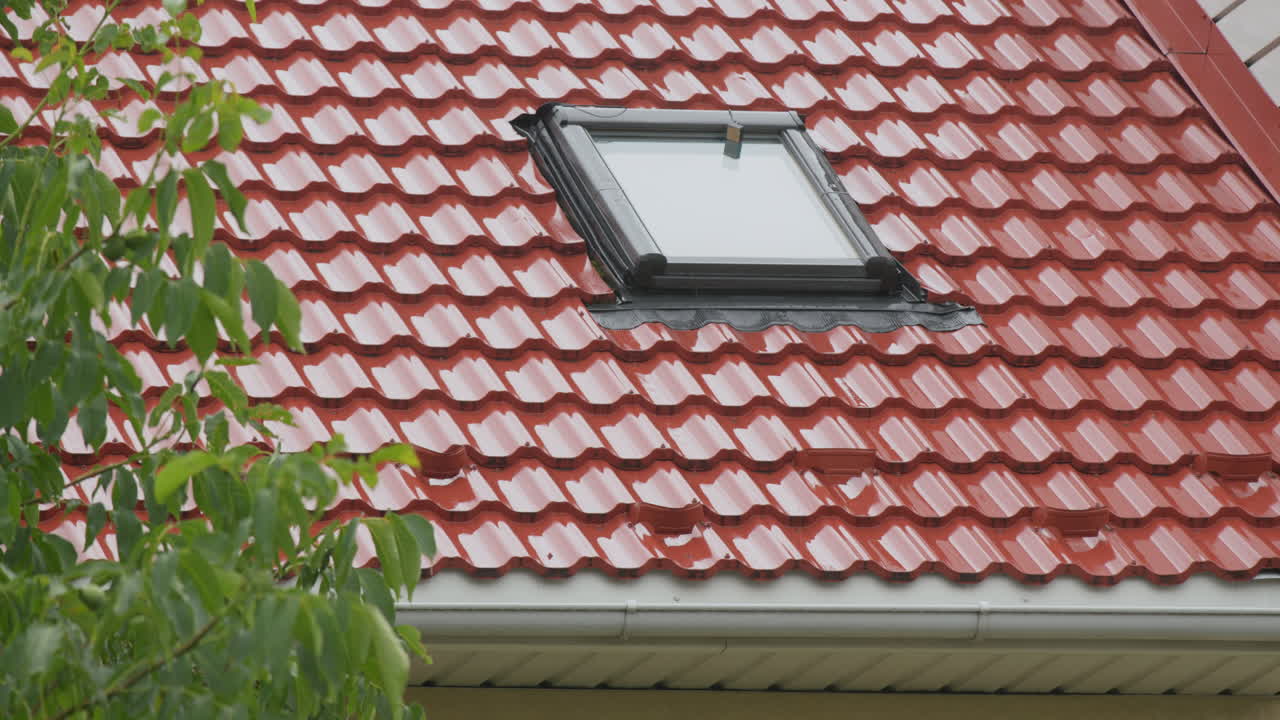 el agua de lluvia fluye por el techo de baldosas hacia la tubería de drenaje