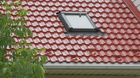 rainwater flows down the tiled roof into the drainpipe