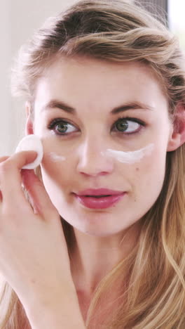 bonitas rubias aplicando crema en su cara