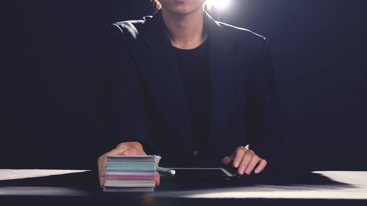 banquero o usurero firma un contrato digital para un préstamo en efectivo - movimiento deslizante aislado en una habitación oscura