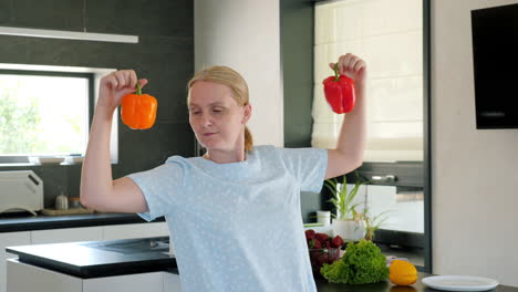 woman holding red and orange bell peppers in a kitchen