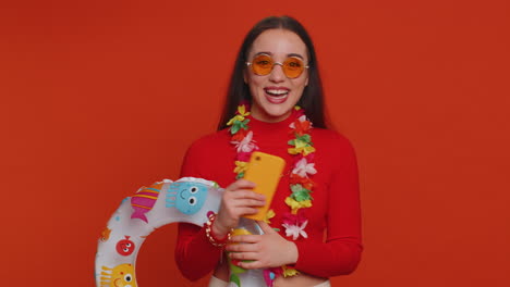 happy woman in summer attire with colorful sunglasses,  a lei, and a beach ring