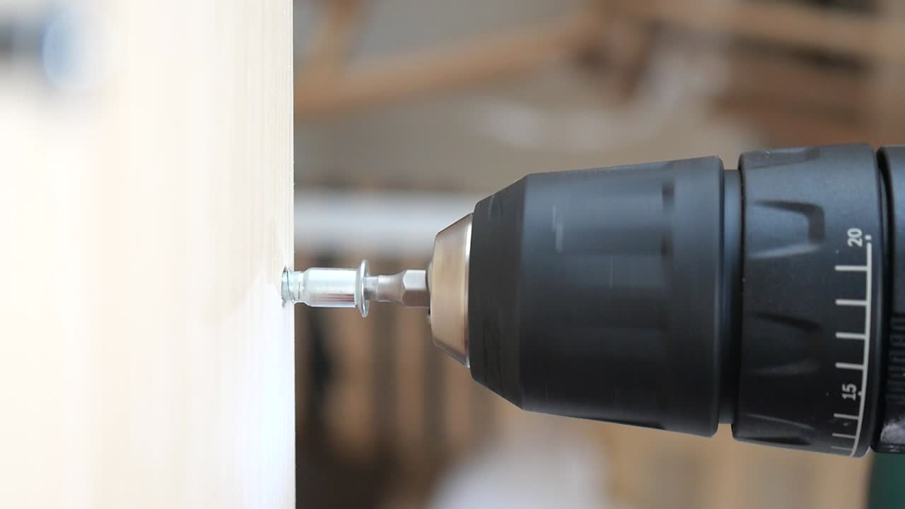 Drilling a screw into wood with a power drill