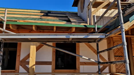 scaffoldings outside unfinished wooden house with attic