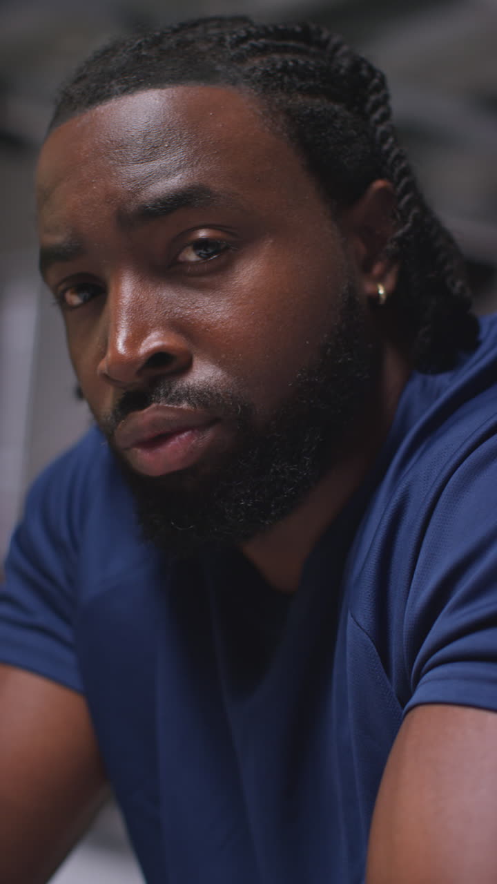 Vertical Video Portrait Of Determined Male Athlete Sport Training In Gym Sitting And Concentrating In Changing Room With Focused Expression 2