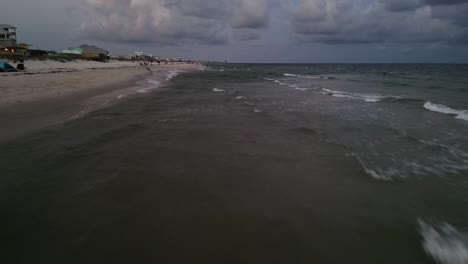 Low-Drone-shot-on-the-Alabama-Coast-at-sunset-on-the-beach