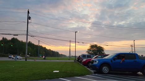 footage of an urban intersection during sunset, featuring vibrant skies and passing vehicles. perfect for projects on city life, travel, and evening scenes.