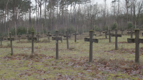 wide pan over old gravestones in weed overgrown cemetary