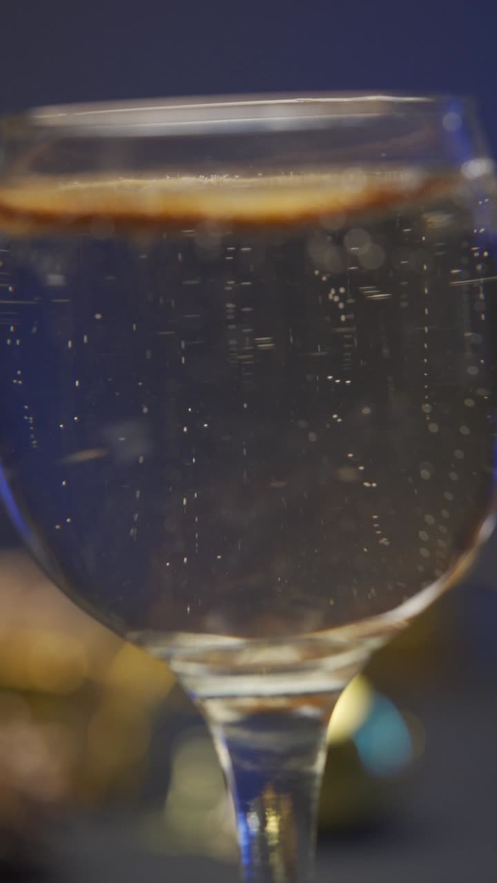 Una bevanda frizzante rinfrescante con bollicine che salgono in un bicchiere, primo piano.