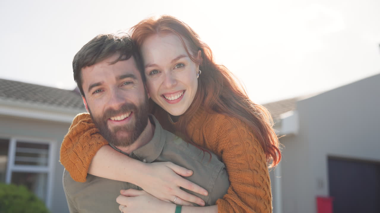 retrato, una pareja feliz abrazada con una casa nueva