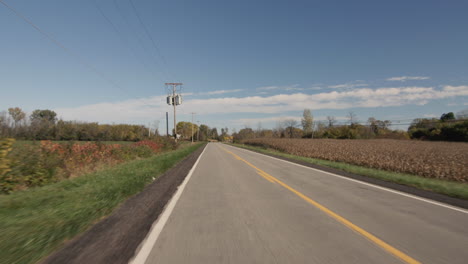 driver's view: driving straight on a flat road in a typical american agricultural region.