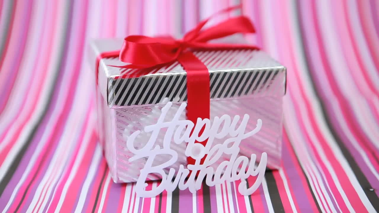 Animation of happy birthday text over present with red ribbon