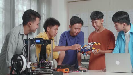 estudiantes trabajando en un proyecto de robótica con una impresora 3d