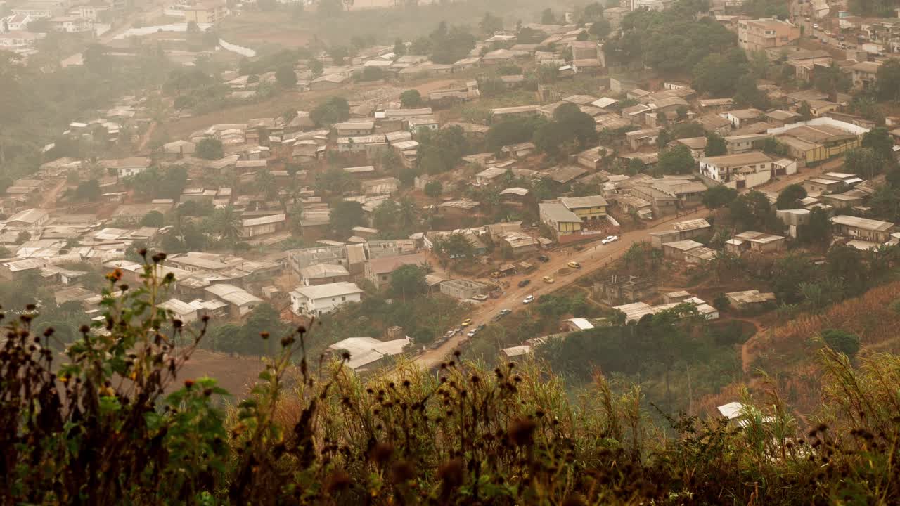 Mange huse bygget på en bjergskråning, der repræsenterer byudvikling i Yaoundé, Cameroun. Bredt panoramabillede