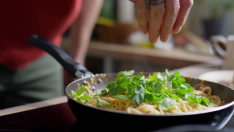 adding fresh parsley to pasta