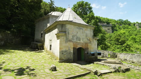 panning from the left to the right showing the front yard and the mausoleum of the alevian saint demir baba teke surrounded by a forested area in isperih, in the province of razgrad, in bulgaria.