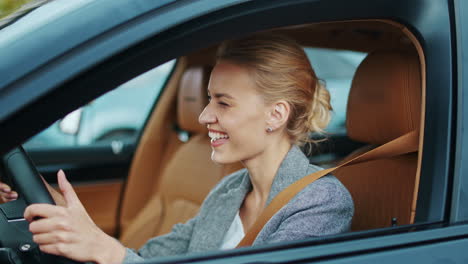 Businesswoman-dancing-at-steering-wheel-in-car