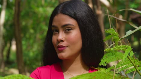 young woman posing in lush green nature