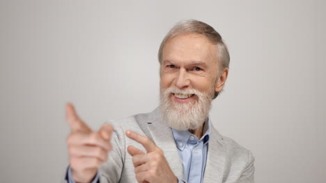 Old-man-pointing-to-camera-inside.-Cheerful-guy-showing-hey-you-sign-indoors.