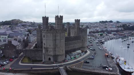 ancient caernarfon castle welsh harbour town aerial view medieval waterfront landmark left dolly closeup