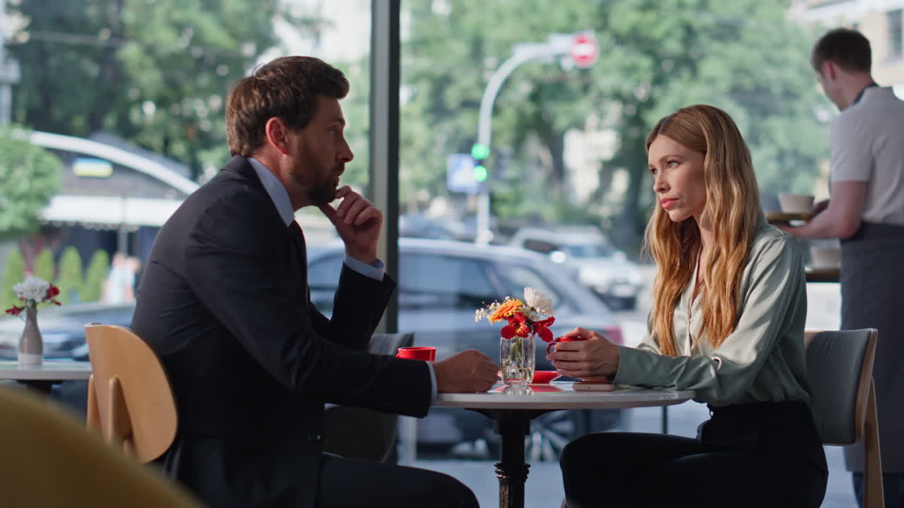 Serious colleagues sitting cafe discussing work problems. Tensed business people
