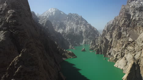 revealing epic aerial drone shot of the rocky sides of the ravine that surrounds the kel-suu lake in kyrgyzstan