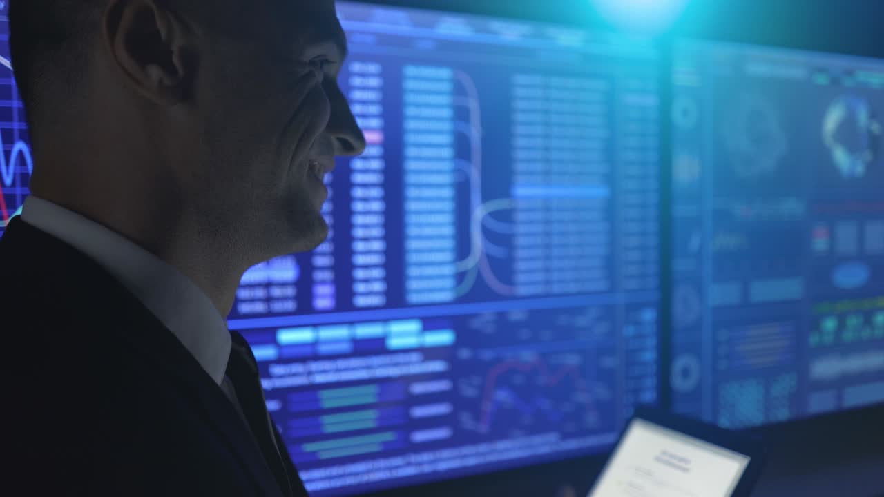 The smiling businessman standing near the blue screen