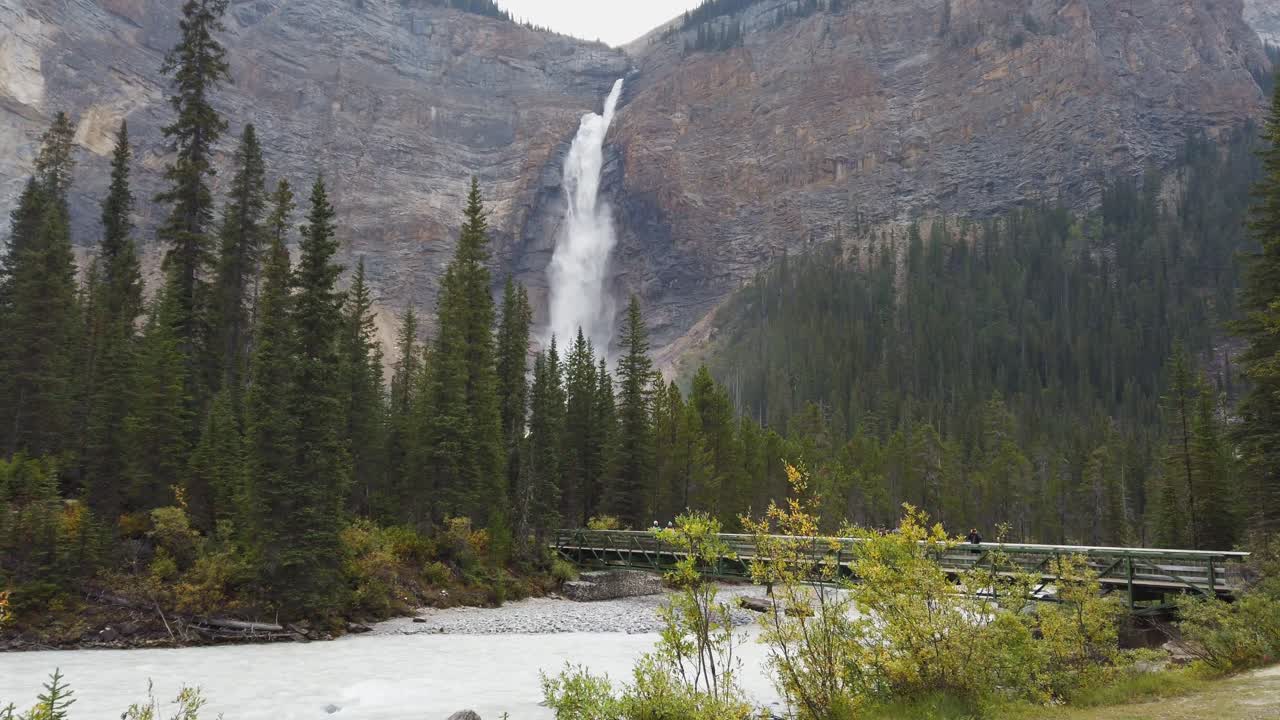Grande cascata Takakkaw Falls nel Parco Nazionale Yoho, Columbia Britannica, con ponte sul fiume e turisti