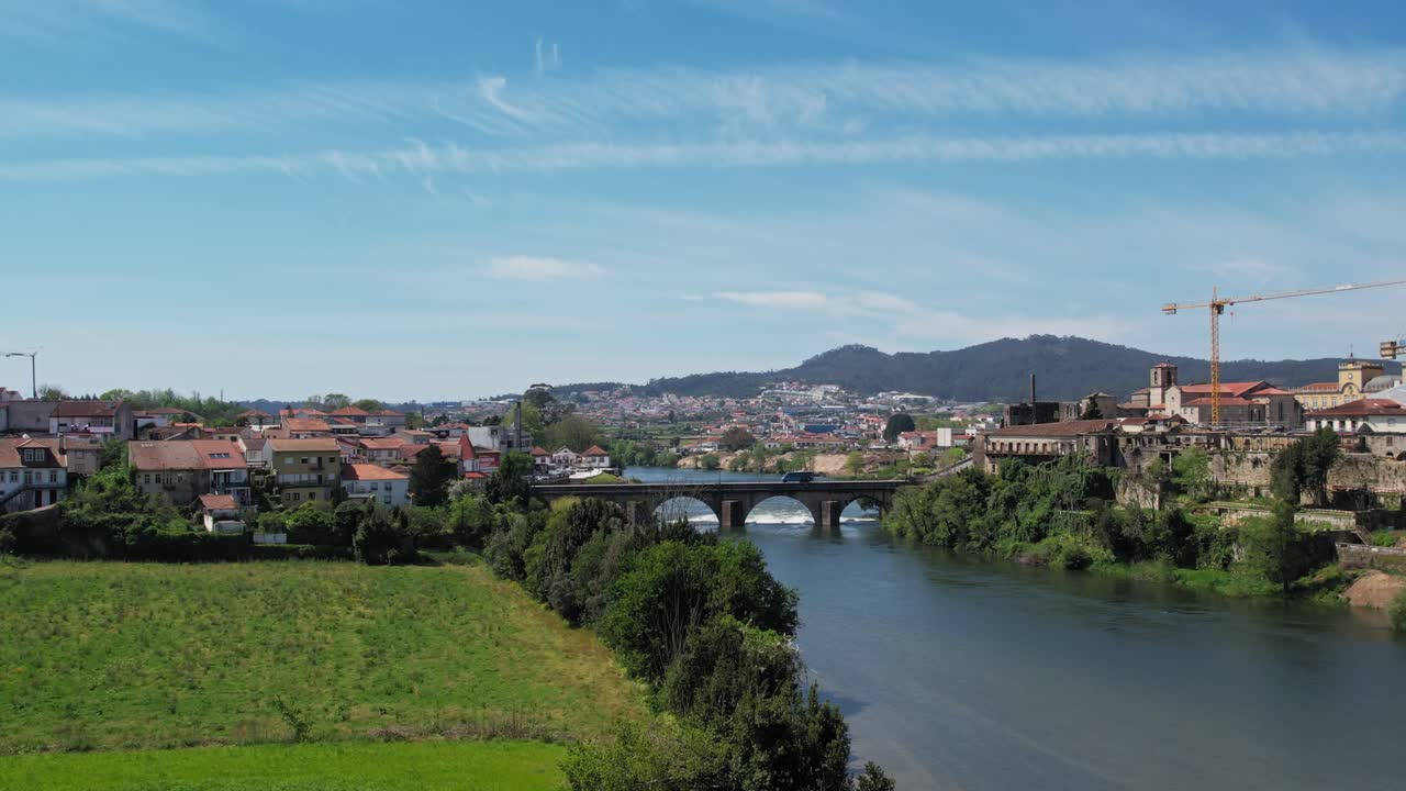 Aerial view of Barcelos, Portugal showcasing its scenic river and medieval bridge under a clear sky