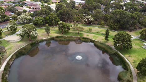 Toma-Aérea-Hacia-Atrás-Sobre-Un-Gran-Lago-Circular-Con-árboles-Establecidos