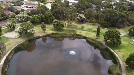 toma aérea hacia atrás sobre un gran lago circular con árboles establecidos