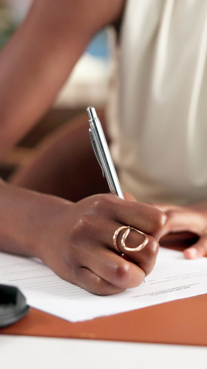 Close-up of a Person's Hand Writing on a Document with a Pen