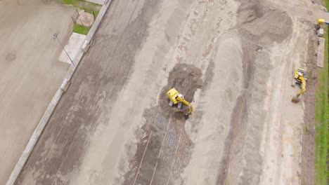wide drone shot showing multiple excavators working together to prepare a sports field for grass installation