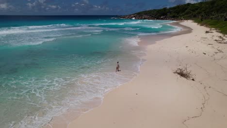 Girl-walks-along-a-beautiful-beach