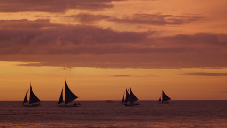 Langsamer-Schwenk-über-Den-Strand-Von-Boracay-Mit-Segelbooten-Während-Des-Sonnenuntergangs